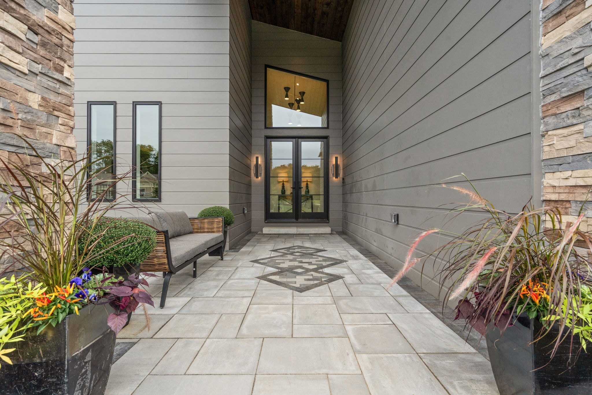 Stone entryway with French doors and decorative tile