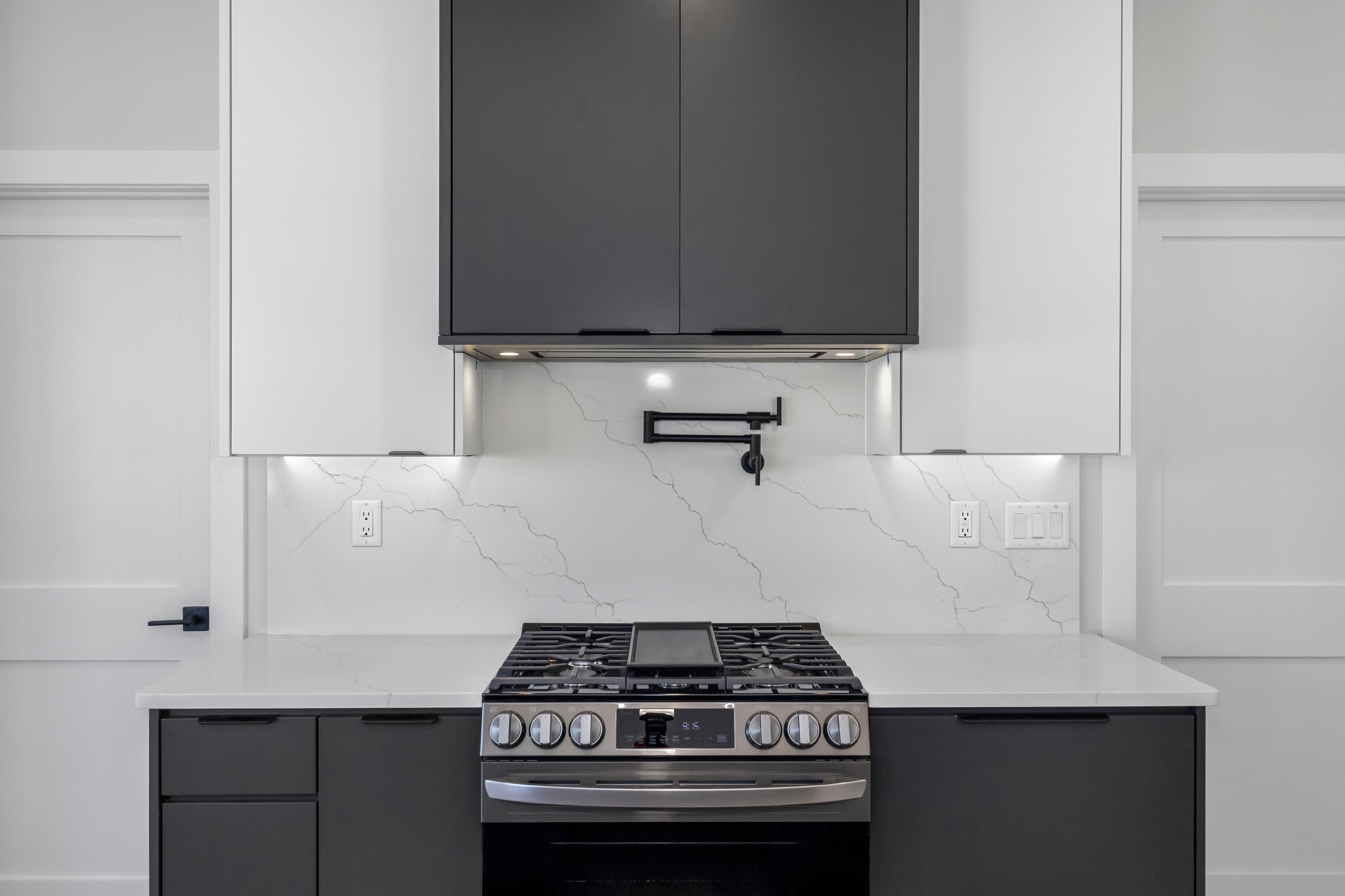 Modern kitchen with gas range and marble backsplash