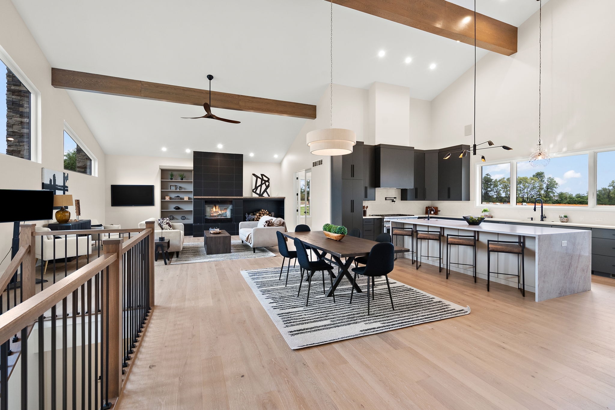 Open concept great room with vaulted ceiling and fireplace