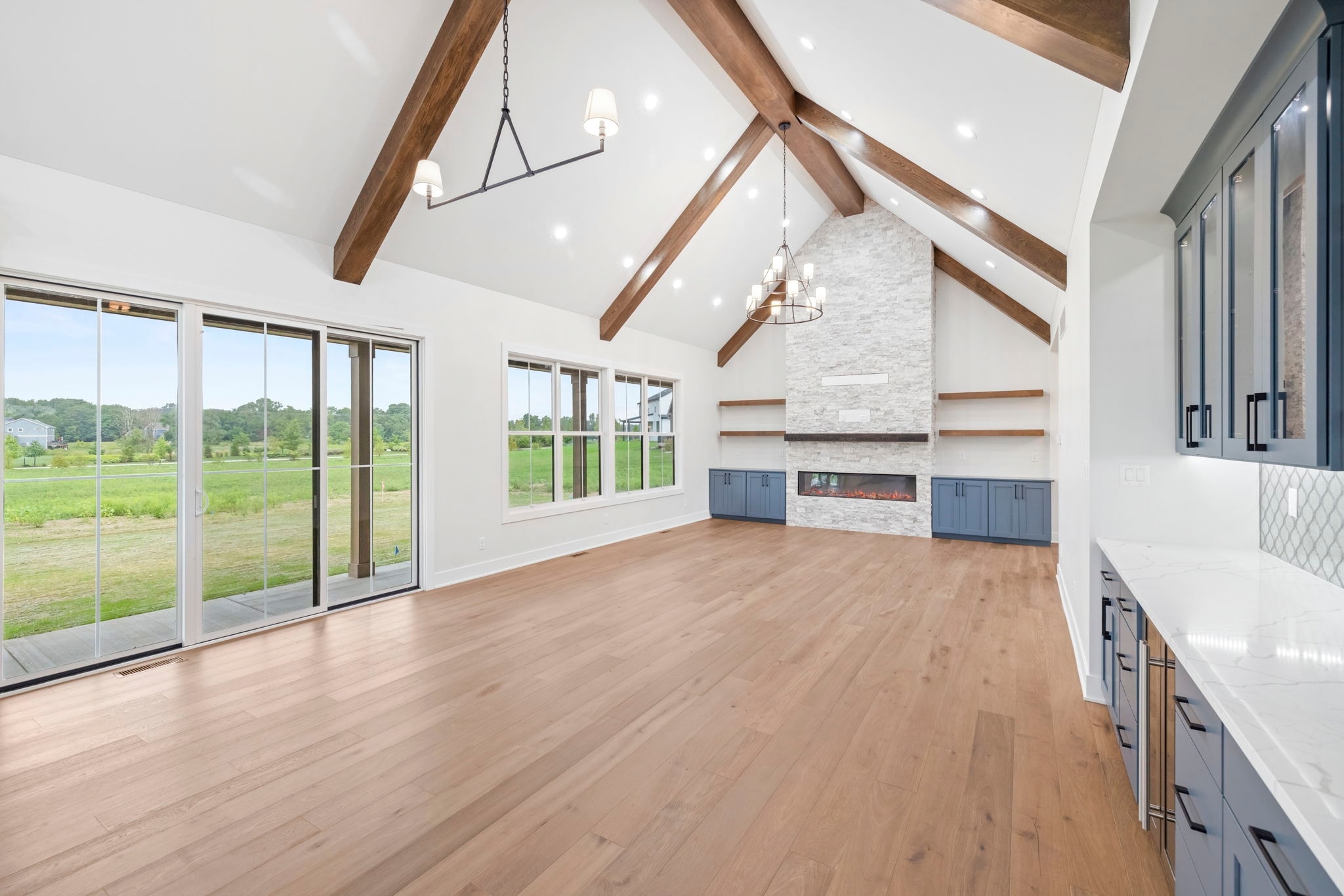 Vaulted beam living room with stone fireplace