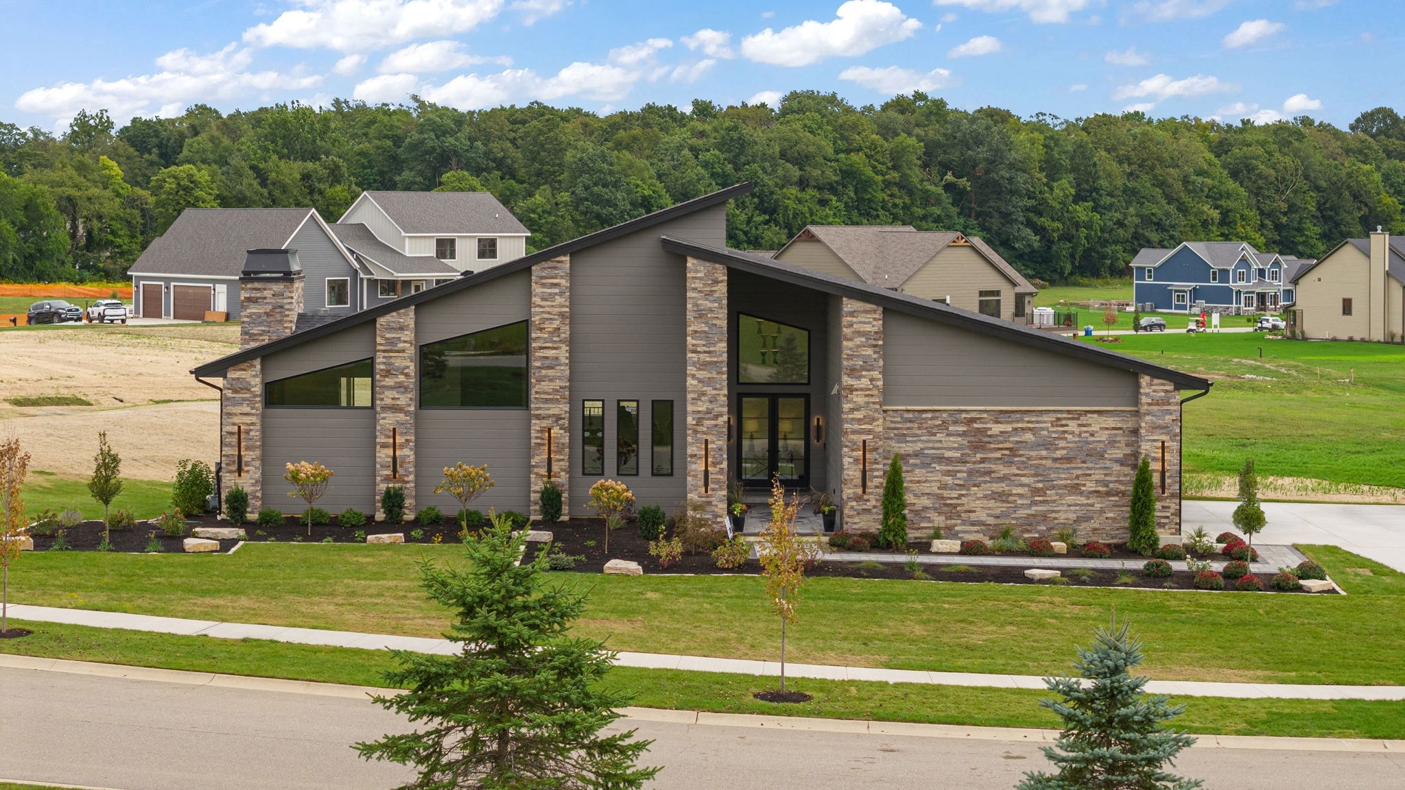 Modern stone and siding home with landscaped front yard