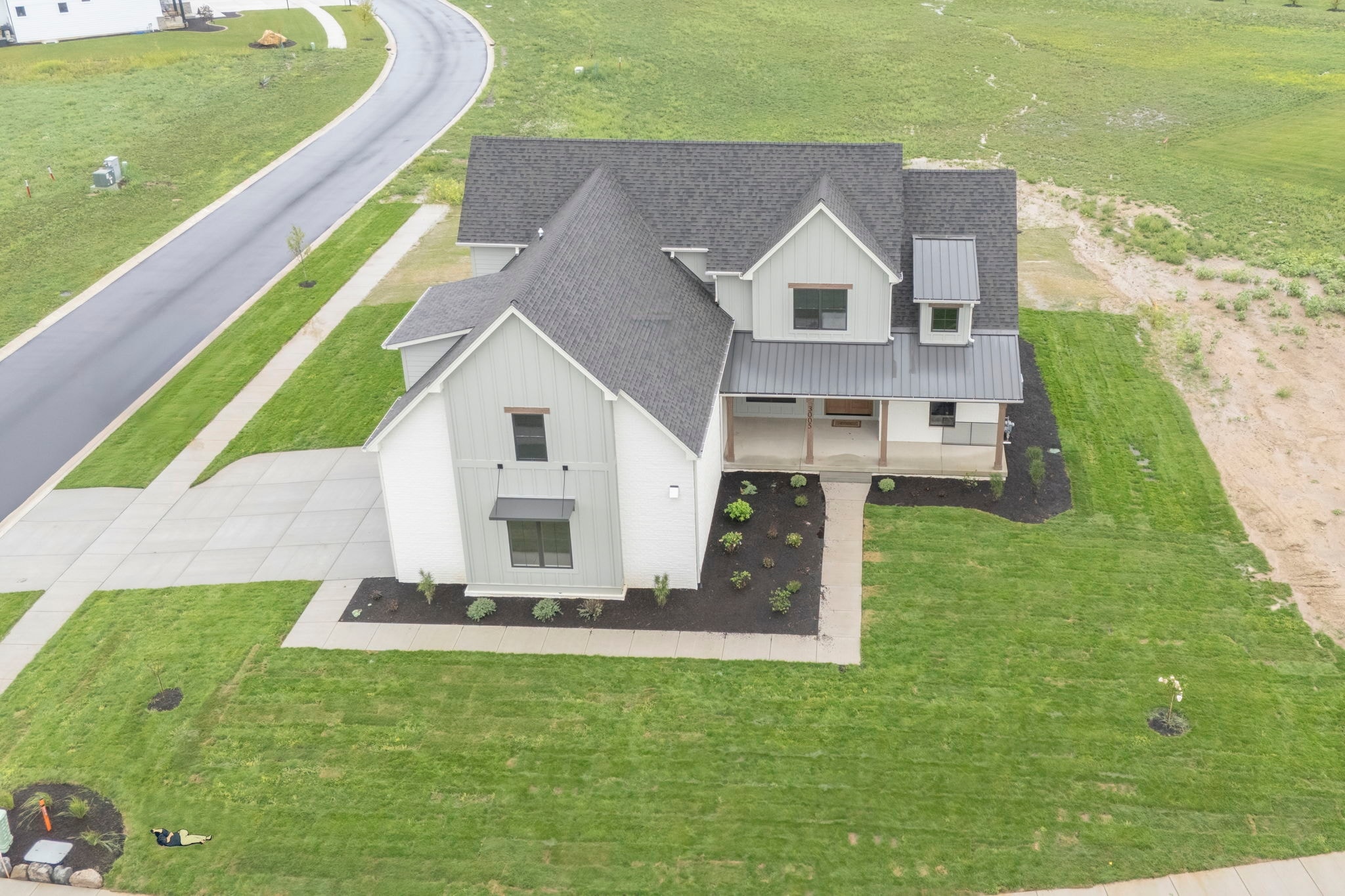 Aerial view of modern farmhouse with metal roof